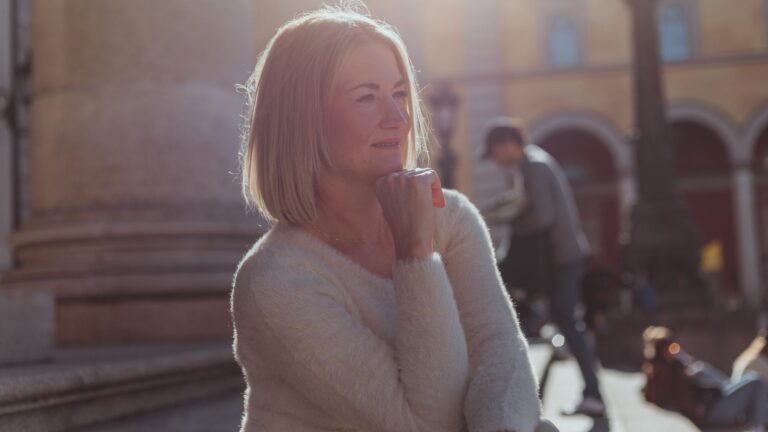 A middle-aged woman enjoying a sunny day outdoors in Munich, Germany.