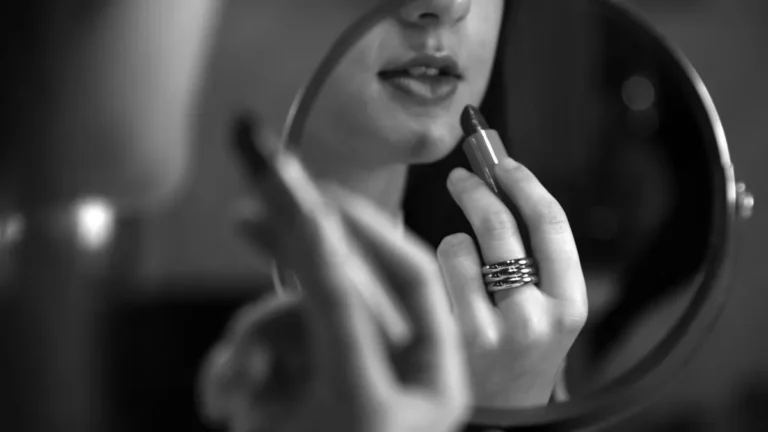 elegant senior woman applying lipstick mirror
