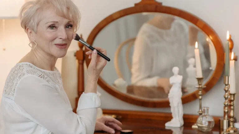 elegant senior woman applying lipstick mirror