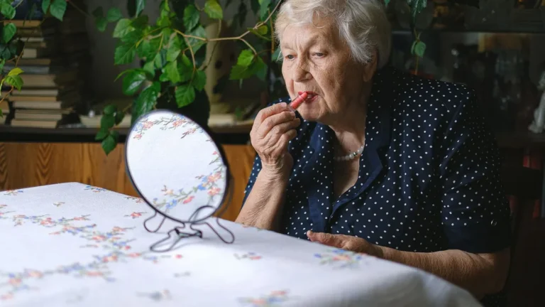 elegant senior woman applying lipstick mirror
