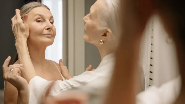 elegant senior woman applying lipstick mirror