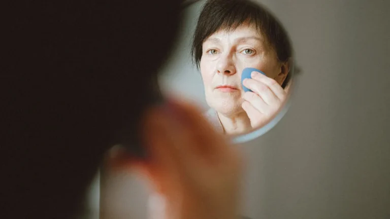 senior woman applying face cream